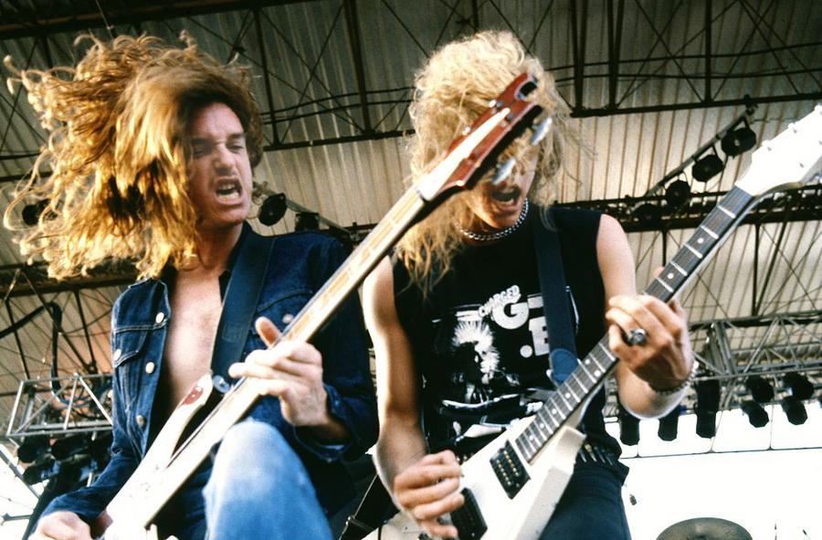 (playing Rickenbacker bass) and James Hetfield (playing Gibson Flying V guitar) performing live onstage 