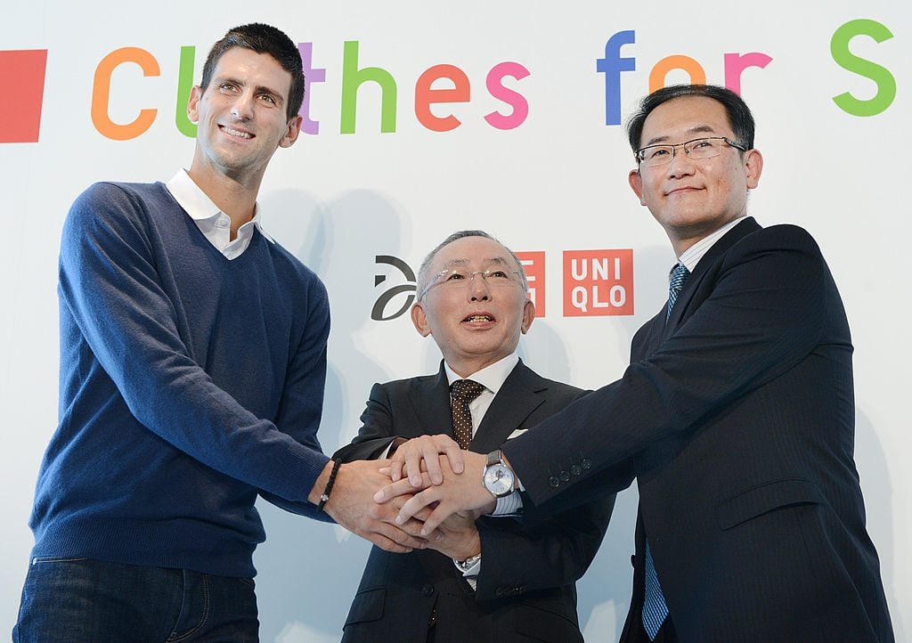 Novak Djokovic (L) shakes hands with Tadashi Yanai