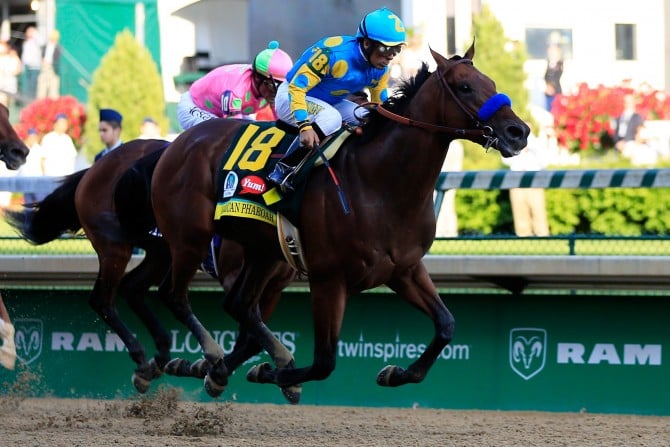 LOUISVILLE, KY - MAY 02:  American Pharoah #18, ridden by Victor Espinoza, leads the field to the finish line ahead of Firing Line #10, ridden by Gary Stevens, during the 141st running of the Kentucky Derby at Churchill Downs on May 2, 2015 in Louisville, Kentucky.  (Photo by Travis Lindquist/Getty Images)